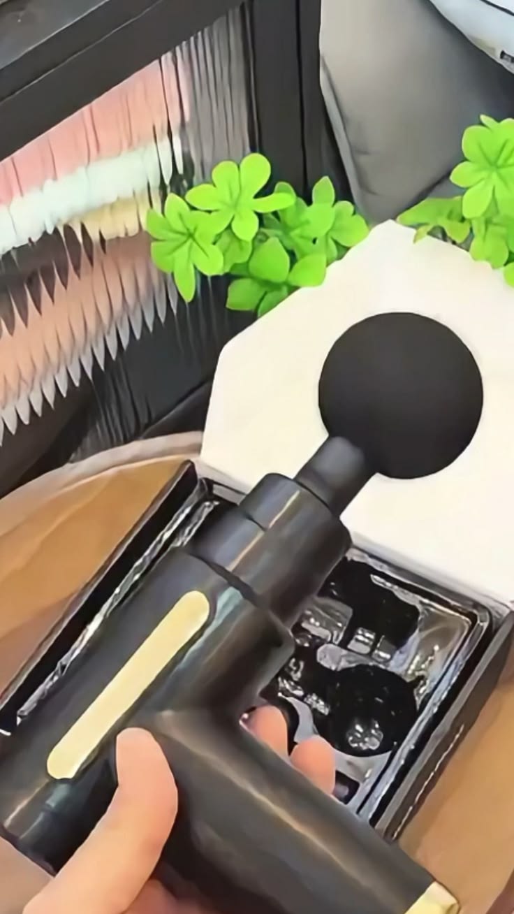 Pistola de Massagem sendo segurada na mão